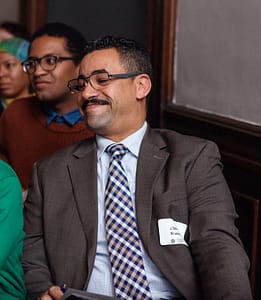Portrait of Ahmed Nasser smiling at a Brooklyn Historical Society lecture.